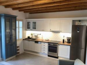 a kitchen with white cabinets and a black refrigerator at Mykonos Summer House in Mikonos