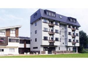 un grand bâtiment blanc avec un toit noir dans l'établissement Villa Schole Hakuba - Vacation STAY 19580v, à Yotsuya