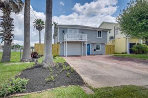 a house with palm trees in front of a driveway at Waterfront Galveston Bay Retreat - 4 Mi to Beach! in Galveston