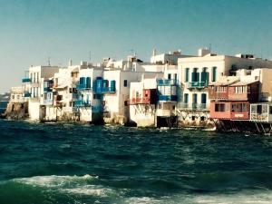 a group of buildings sitting on the water next to a city at Mykonos Summer House in Mikonos
