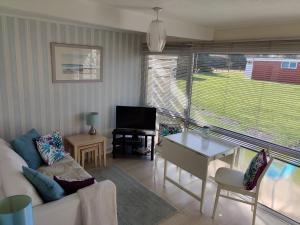 a living room with a couch and a table and a tv at Heacham Hideaway in Heacham