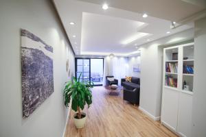ein Wohnzimmer mit einem Sofa und einer Topfpflanze in der Unterkunft Modern Super Chic Duplex with a Terrace at the heart of city! in Istanbul