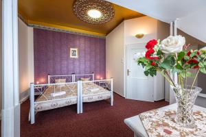 a bedroom with two beds and a table with a vase of flowers at Historic Villa "Imperia" in Prague