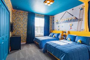 Duas camas num quarto com paredes azuis e amarelas em Beautiful 5bed home close to Disney 1131KING em Kissimmee