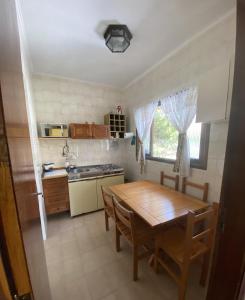 a kitchen with a wooden table and a dining room at Chalé Aconchegante 2km do Centrinho in Campos do Jordão
