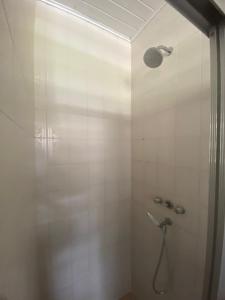 a bathroom with a shower with a shower head at Chalé Aconchegante 2km do Centrinho in Campos do Jordão