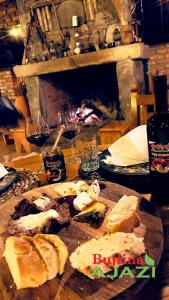 una mesa con un plato de pan y copas de vino en Bujtina Ajazi en Golem