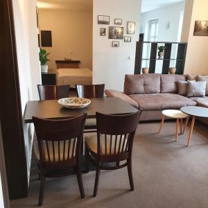- un salon avec une table, des chaises et un canapé dans l'établissement Ferienapartment Lilo, à Eisenhüttenstadt