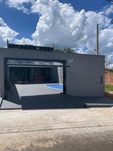 ein Gebäude mit einer Garage und einem Pool in der Unterkunft Casa de temporada Stracini in Taquaritinga
