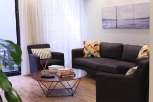 ein Wohnzimmer mit einem Sofa und einem Couchtisch in der Unterkunft Modern Super Chic Duplex with a Terrace at the heart of city! in Istanbul