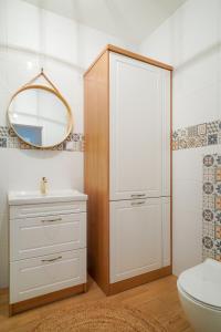 a bathroom with a toilet and a sink and a mirror at Apartament Gdańsk Premium Porto in Gdańsk