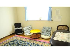 Pokój z 3 krzesłami, stołem i dywanem w obiekcie Petit Hotel Koizumi - Vacation STAY 85672v w mieście Tōya-ko