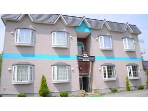 a pink house with a blue trim at Petit Hotel Koizumi - Vacation STAY 85672v in Lake Toya