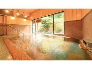 Saikatei Jidaiya - Vacation STAY 96432v في Kaminoyama: غرفة مع تجمع للمياه في المنزل