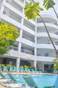 a hotel with a swimming pool and chairs and a building at Portobelo Plaza de las Americas in San Andrés