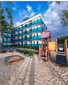 um edifício com um parque infantil em frente a um edifício em Aquarius Residence Apartament 104 em Boszkowo