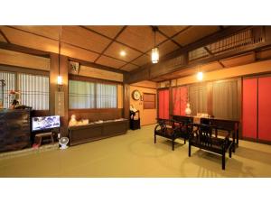 uma sala de estar com um sofá, uma mesa e cadeiras em Saikatei Jidaiya - Vacation STAY 96432v em Kaminoyama