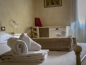 een slaapkamer met handdoeken op een bed met een tafel bij Borgo Pian di Sala in San Gimignano