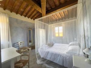 a bedroom with a white bed with a window at Borgo Pian di Sala in San Gimignano