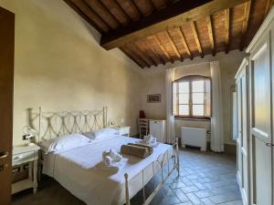 a bedroom with a large bed in a room with a window at Borgo Pian di Sala in San Gimignano