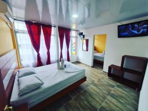 a bedroom with a bed with red curtains at Hotel las Corocoras del llano in Villavicencio