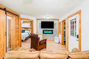 uma sala de estar com um sofá, uma cama e uma televisão em Cozy Cub Mountain Escape em Gatlinburg