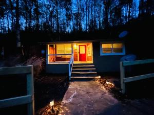 uma casa com uma porta vermelha e escadas à noite em Cozy Cub Mountain Escape em Gatlinburg