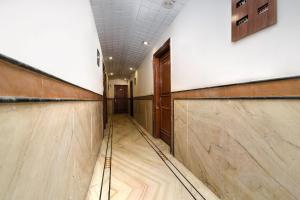 a long hallway with wooden stalls in a building at Capital O Corporate Inn in New Delhi