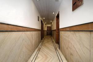 a long hallway with wood flooring in a building at Capital O Corporate Inn in New Delhi