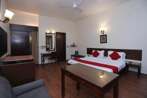 une chambre d'hôtel avec un lit et un canapé dans l'établissement Hamilton Hotel, à New Delhi