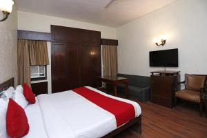 Habitación de hotel con cama y TV de pantalla plana. en Hamilton Hotel, en Nueva Delhi