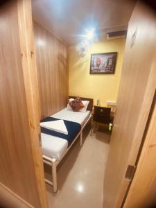 Habitación pequeña con cama y escritorio. en Royal Cabin Stay, en Bombay