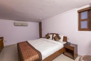 1 dormitorio con cama, mesa y ventana en OYO Hotel Landmark Inn en Nueva Delhi