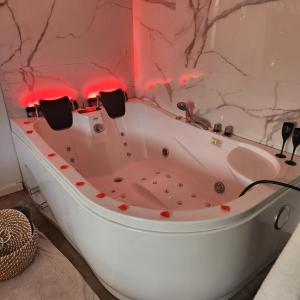 La salle de bains est pourvue d'une baignoire et de lumières rouges. dans l'établissement coconbleu, balnéo double, à Solliès-Toucas