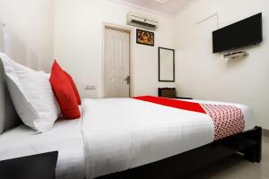 a bedroom with a bed with red and white pillows at Collection O Ramji 7 Grand Near Tdi Mall in New Delhi