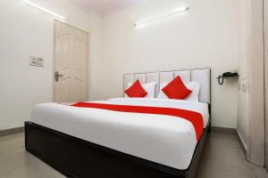a bedroom with a large white bed with red pillows at Collection O Ramji 7 Grand Near Tdi Mall in New Delhi