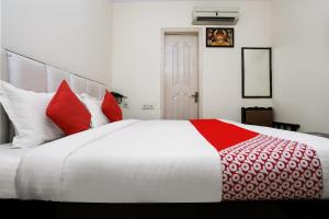 a large bed with red and white pillows on it at Collection O Ramji 7 Grand Near Tdi Mall in New Delhi