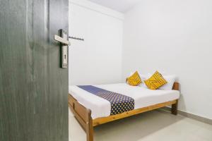 a small bed in a room with a door at SPOT ON Rohini Inn Kadampuzha in Kottakkal