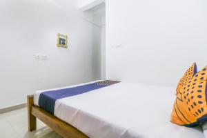 a small bed in a white room with at SPOT ON Rohini Inn Kadampuzha in Kottakkal