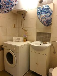 ein Badezimmer mit einer Waschmaschine und einem Waschbecken in der Unterkunft Olympia's apartment in Skopje
