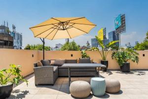 a patio with a table and an umbrella at H4U l Amplio apartamento de lujo 2 Hab + Terraza privada in Mexico City