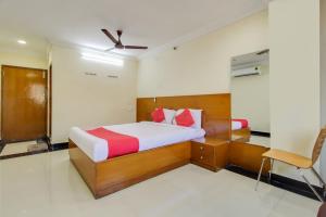 a bedroom with a bed and a chair in it at OYO Srinivasa Residency in Tirupati
