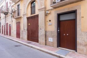 a row of wooden doors on the side of a building at Vivarum b&b in Bitonto