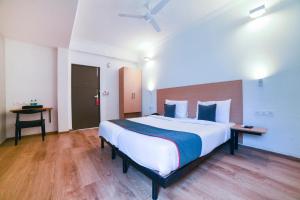- une chambre avec un grand lit blanc et des oreillers bleus dans l'établissement Collection O 142 Vadapalani, à Chennai