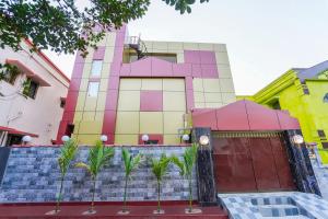 un edificio colorido con palmeras delante en OYO Home Exotic Stay, en Bhubaneshwar