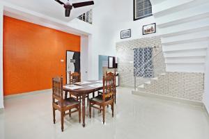 ein Esszimmer mit einem Holztisch und Stühlen in der Unterkunft OYO Home Exotic Stay in Bhubaneshwar