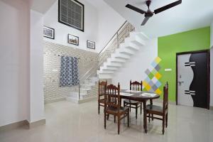 un comedor con mesa y sillas y una escalera en OYO Home Exotic Stay, en Bhubaneshwar