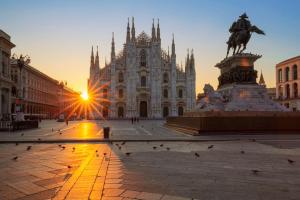 ein großes Gebäude mit einer Statue davor in der Unterkunft City Life House-YELLOW San Siro & Duomo in Mailand