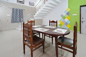 a dining room with a wooden table and chairs at OYO Home Exotic Stay in Bhubaneshwar