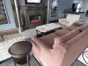American Inn & Suites في Ferndale: غرفة معيشة مع أريكة ومدفأة